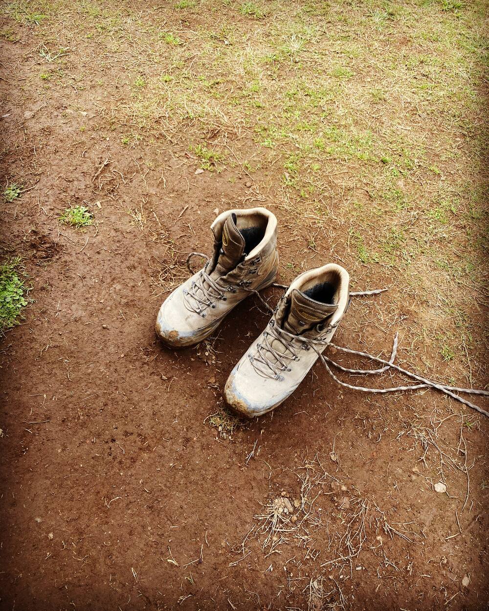 Chaussures de montagne usées et poussiéreuses après la voie Machame